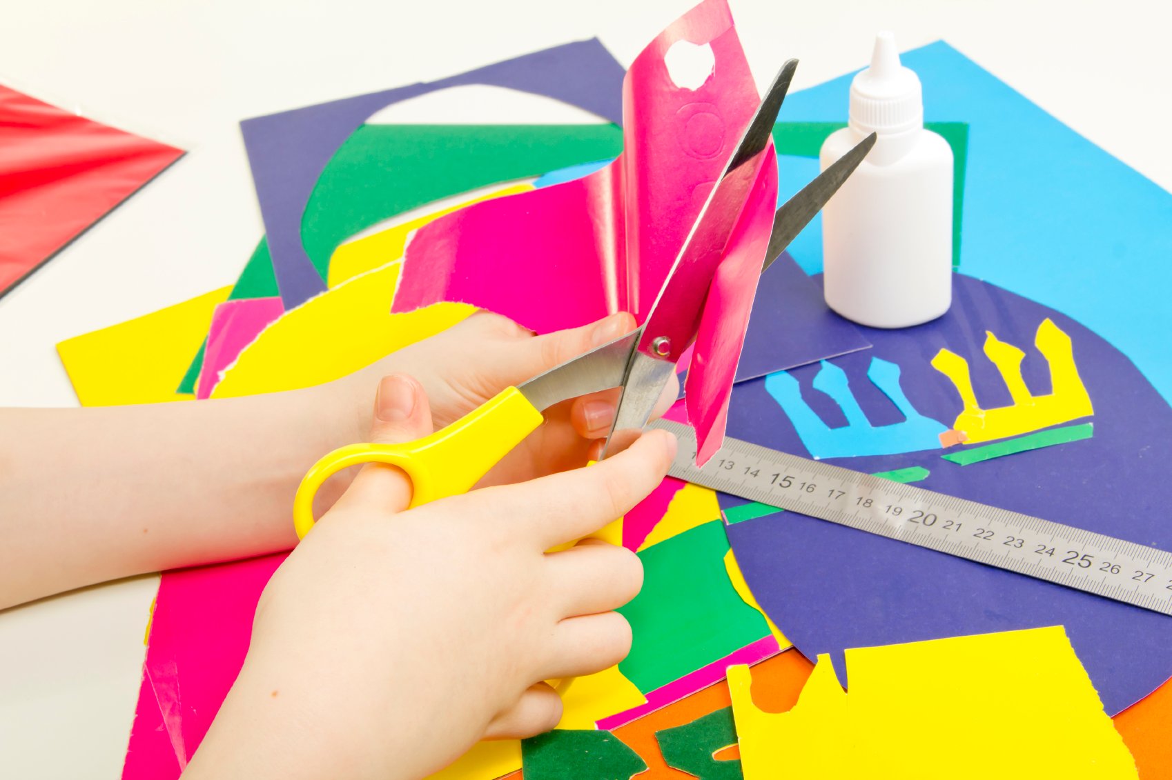 Colored paper, glue, scissors and children’s handmade card