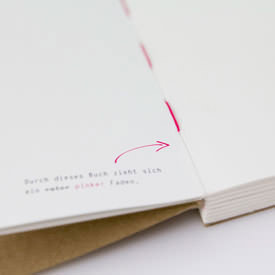 Detailansicht der Fadenheftung vom Design-Notizbuch mit offenem Buchrücken